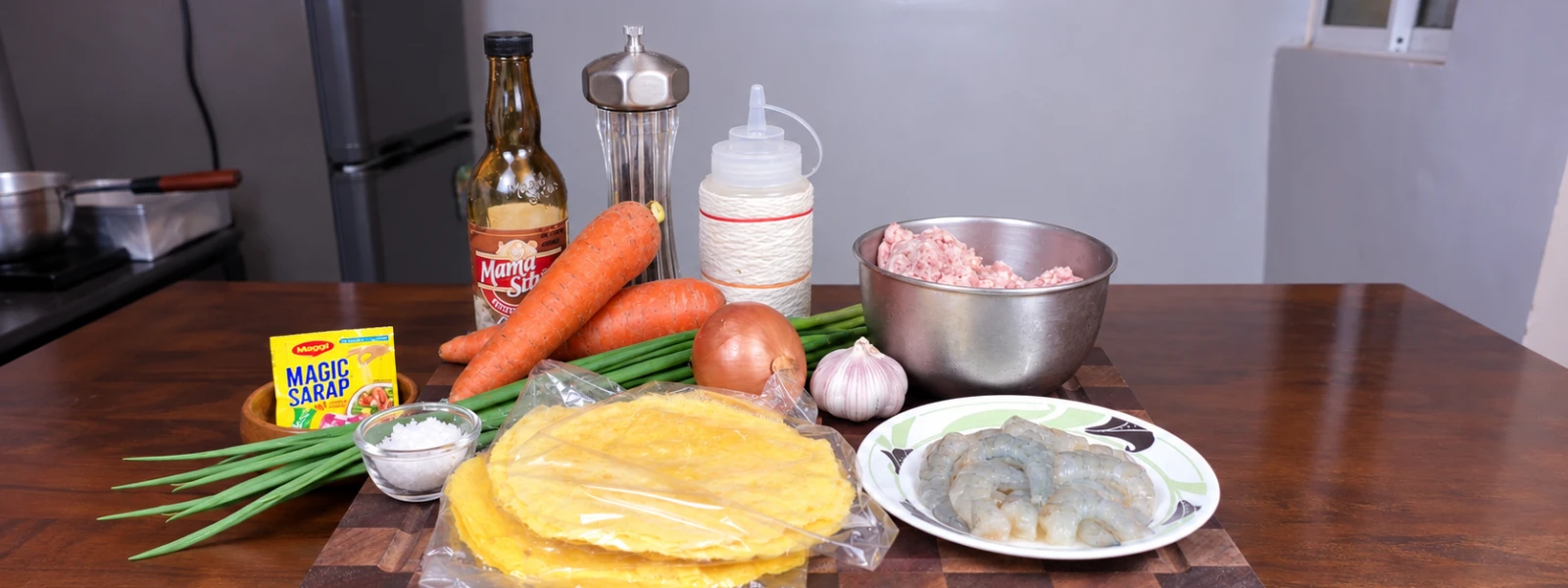 Ingredients for Lumpiang Shanghai arranged on a wooden chopping board.